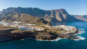 an island in the ocean with mountains in the background at Occidental Roca Negra - Adults Only in Agaete