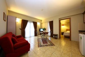 a living room with a red couch and a bedroom at Mr. Dim Exclusive Apart Hotel in Göcek