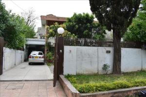 a fence with a car parked in front of a house at Tulip guesthouse in Islamabad