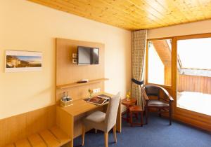 a hotel room with a desk and a tv at Stahlecker Hof in Lichtenstein