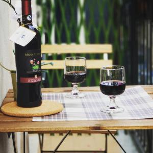 eine Flasche Wein und zwei Gläser auf dem Tisch in der Unterkunft Cassatella House in Catania