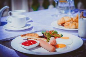 a plate of food on a table with eggs and bread at Parliament Palace Hotel in Khujand