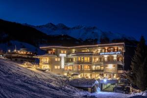 un grande edificio nella neve di notte di Hotel Appart Peter a Sölden