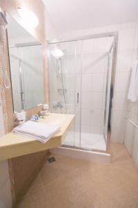 a bathroom with a shower and a sink at Hotel International in Baile Felix