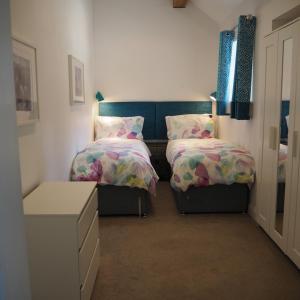 1 dormitorio con 2 camas individuales y vestidor en Old Stables en Pulborough