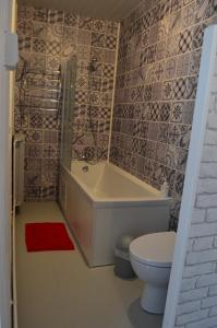 ein Bad mit einer Badewanne und einem WC in der Unterkunft L'Amandier in Maury