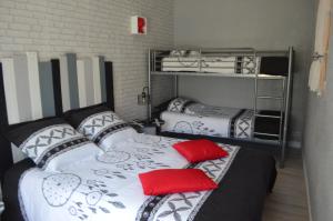 a room with two bunk beds with red pillows at L'Amandier in Maury