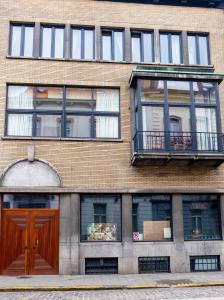 un edificio de ladrillo con una puerta y ventanas marrones en Quartier Leonard en Ghent