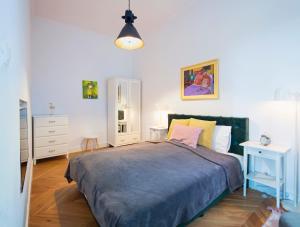 a bedroom with a large bed with a blue blanket at TCF Home - Modern Apartments 2 in Kraków