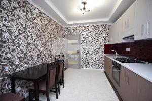 a kitchen with a black and white patterned wall at Alba-Iulia Vip Residence in Chişinău