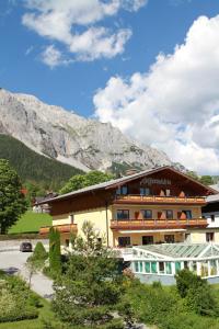 un hôtel avec une montagne en arrière-plan dans l'établissement Aparthotel Pfeffermühle, à Ramsau am Dachstein