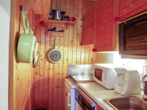 - une cuisine avec des murs en bois et un comptoir avec un four micro-ondes dans l'établissement Apartment Le Carlton-5 by Interhome, à Chamonix-Mont-Blanc