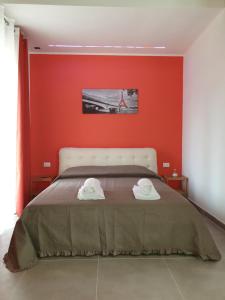 1 dormitorio con paredes rojas y 1 cama con 2 toallas blancas en Campagna D'aMare, en Atessa