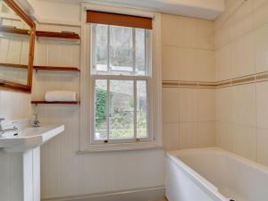 リンマスにあるHoliday Home Summervilleのバスルーム(バスタブ、シンク付)、窓が備わります。