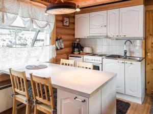 uma cozinha com armários brancos e uma ilha de cozinha em Holiday Home Lintukoto by Interhome em Äkäslompolo