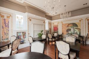 a dining room with tables and chairs and a chandelier at Boreland Lodge Hotel in Inverkeithing
