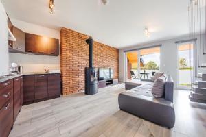 a kitchen and living room with a brick wall at Apartamenty Sun & Snow Jantar Park in Jantar