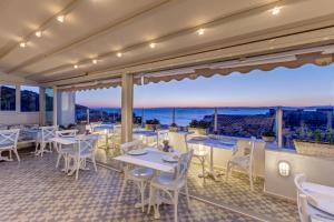 a restaurant with tables and chairs and a view of the ocean at Ela Tenedos Hotel - Special Category in Bozcaada
