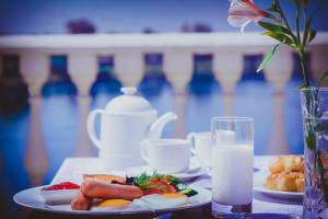 a table with plates of food and a glass of milk at Parliament Palace Hotel in Khujand