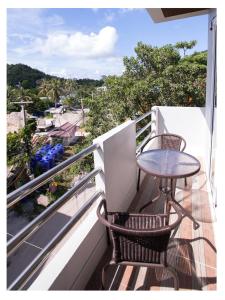 a balcony with a table and chairs and a view at Namhasin House in Koh Tao
