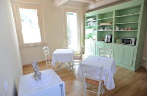 a dining room with white tables and a green cabinet at Il Giardino Del Conte Custoza in Marmirolo +11 photos