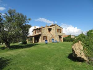 a stone house with a blue chair in a yard at Agriturismo Le Sorgenti in Pitigliano