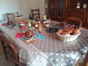 einen Tisch mit einem Tischtuch und Brotkörben in der Unterkunft Le Mas du Berger in Saint-Quentin-la-Poterie