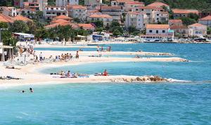 a group of people on a beach in the water at Apartment Gloria in Trogir