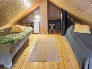 a room with two beds and a rug in a cabin at Holiday Home Lintukoto by Interhome in Äkäslompolo