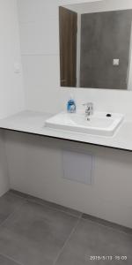 W łazience znajduje się biała umywalka i lustro. w obiekcie WHITE CORAL CLUB w Koszycach
