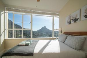 sypialnia z dużym oknem z widokiem na góry w obiekcie Disa Park 16th Floor Apartment with City Views w Kapsztadzie