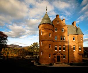 a large brick building with a tower on top at Fonab Castle Hotel in Pitlochry