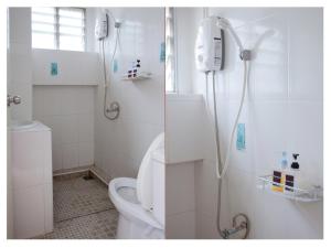 a white bathroom with a shower and a toilet at Namhasin House in Ko Tao