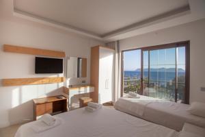 a hotel room with two beds and a large window at Hotel Ferah in Kaş