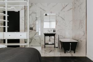 Baño blanco con bañera y lavamanos en TG Hotel Apartments Budapest, en Budapest