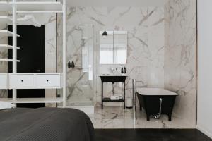ブダペストにあるTG Hotel Apartments Budapestの浴槽と洗面台のある白いバスルーム