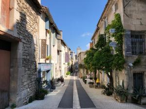 eine Gasse in einer Altstadt mit Gebäuden in der Unterkunft Le Sommeil des Fées in Saint-Rémy-de-Provence