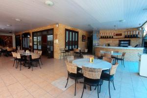 a restaurant with tables and chairs and a bar at Hotel Terral in Pindoretama