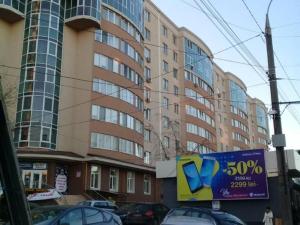 um grande edifício com carros estacionados em frente em Alba-Iulia Vip Residence em Chisinau