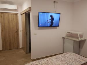 um quarto com uma televisão na parede em O Cantinho em Quinta do Anjo