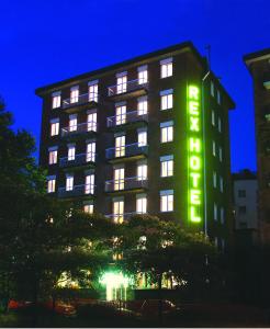 a hotel with a neon sign on the side of it at Hotel Rex Milano in Milan