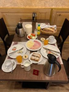 una mesa de madera con platos de comida. en Pension Ulrika, en Loket