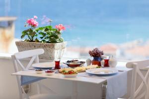 a table with plates of food on a table at Ela Tenedos Hotel - Special Category in Bozcaada