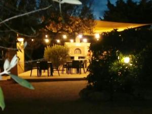 un patio con mesa y sillas por la noche en Agriturismo Grotta Di Figazzano, en Cisternino