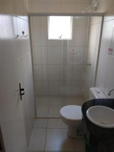 ein weißes Bad mit einem WC und einem Waschbecken in der Unterkunft Residencial Melfi 3 Ap. 7 Fundos in Bombinhas