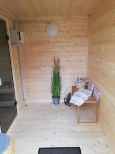 a wooden sauna with a bench and a plant at Ferienhus Wattkinner in Tönning