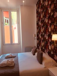 um quarto com uma cama com uma parede floral em Appart Hotel Garibaldi em Nice