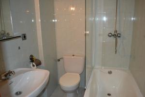 a white toilet sitting next to a bath tub in a bathroom at Hotel Sena in Caldas de Reis