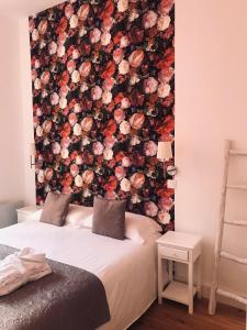 um quarto com uma parede floral atrás da cama em Appart Hotel Garibaldi em Nice