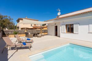 a villa with a swimming pool and a house at Berganti in Port d'Alcudia
